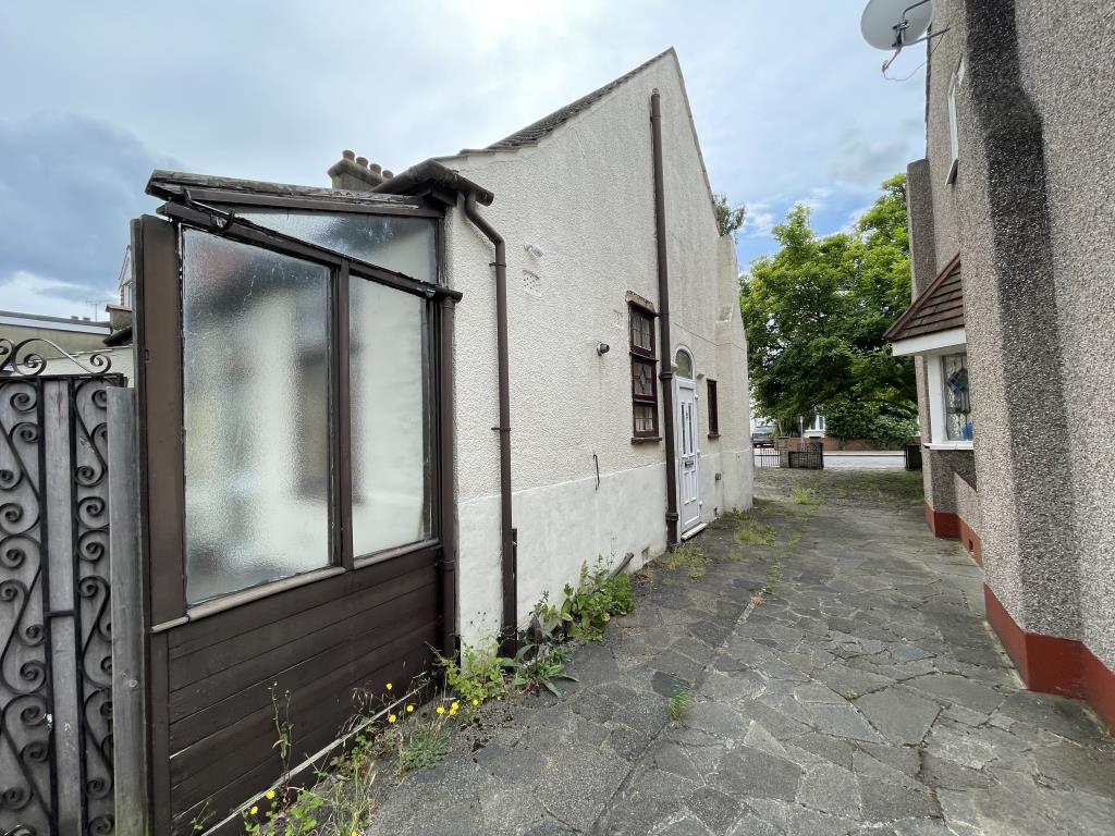 Lot: 27 - SEMI-DETACHED BUNGALOW WITH GARAGE FOR IMPROVEMENT - outside photo of the side access looking away from the garage up the driveway